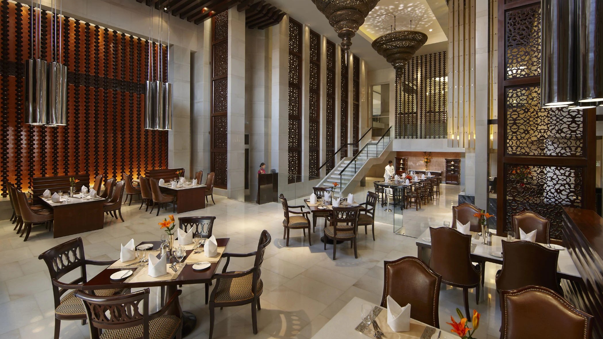 Dining area with marble floor and brown furniture at Mughal Pavillion at the ITC