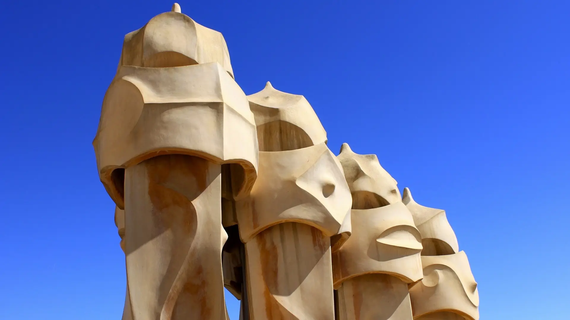 Four face statues in Barcelona with a sand colouring also known as Casa Mila.