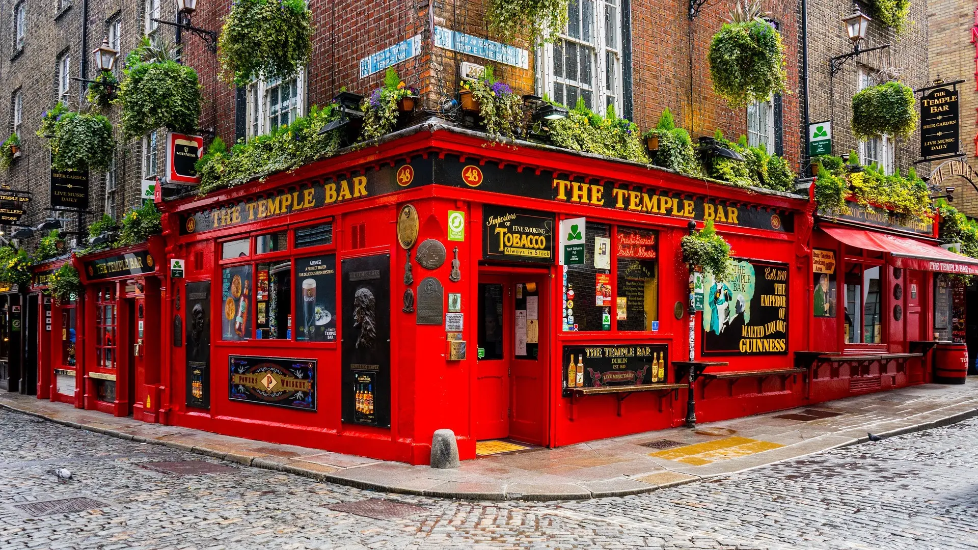 THE TEMPLE BAR with a brigth red design, posters and small windows sorounded by brick design in Dublin.