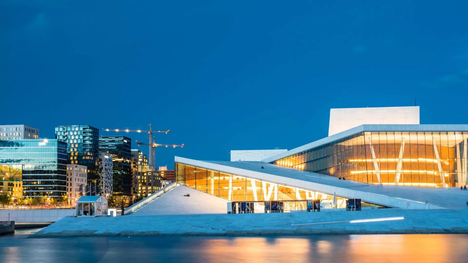 The Opera House in Oslo, Norway. With large glass windows covering floor to ceiling, and futuristic white design.