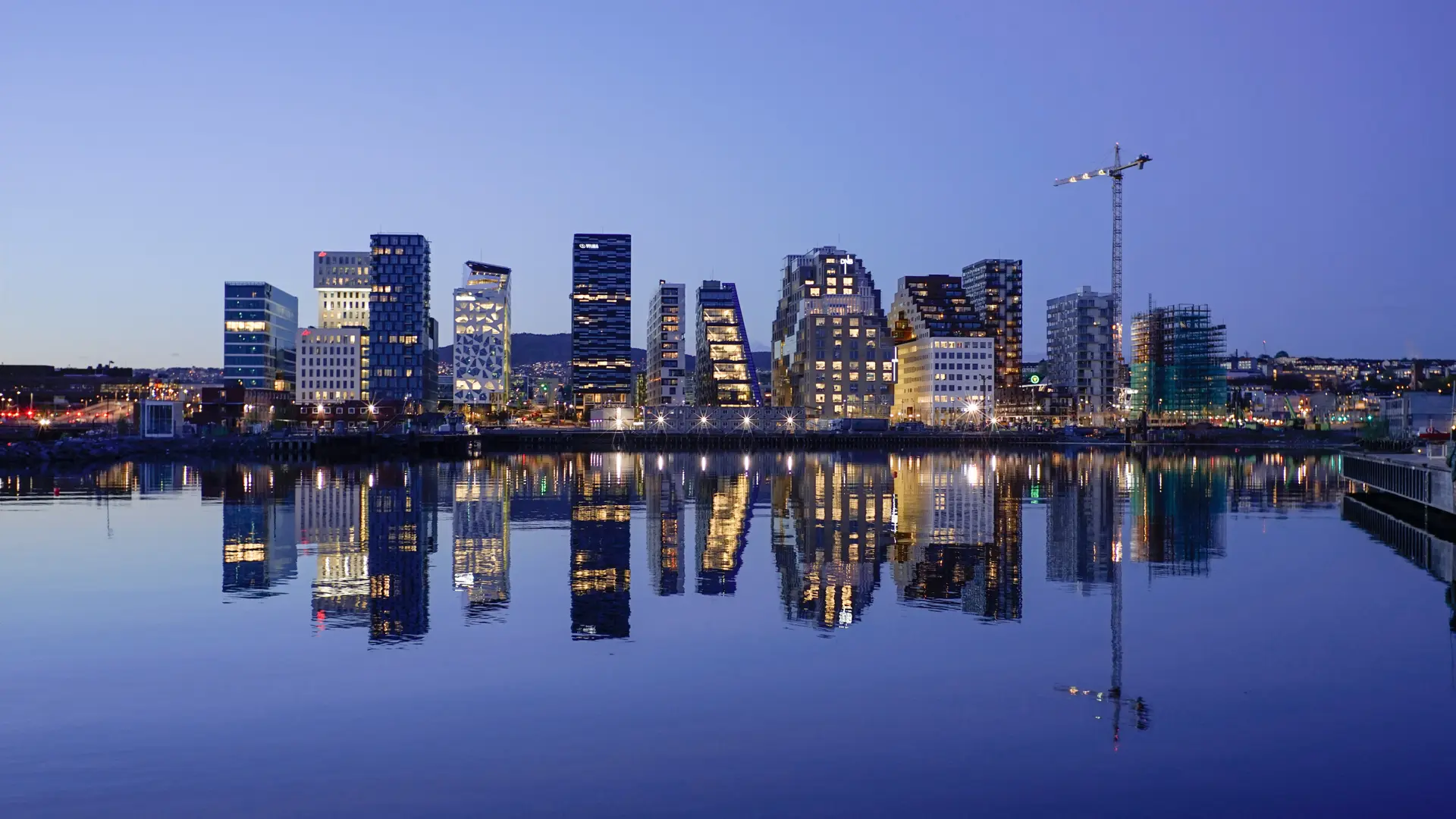 View from the water of capital of Norway, Oslo. With large and tall buildings, cool water and city lights.