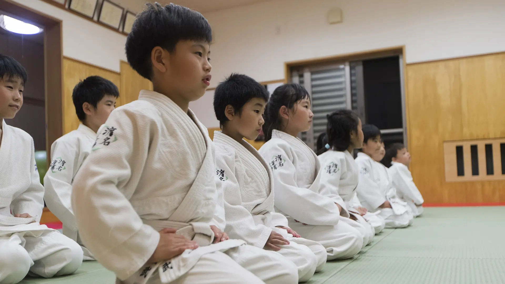 Nine kids doing martial arts with white kimono's in Tokyo. 