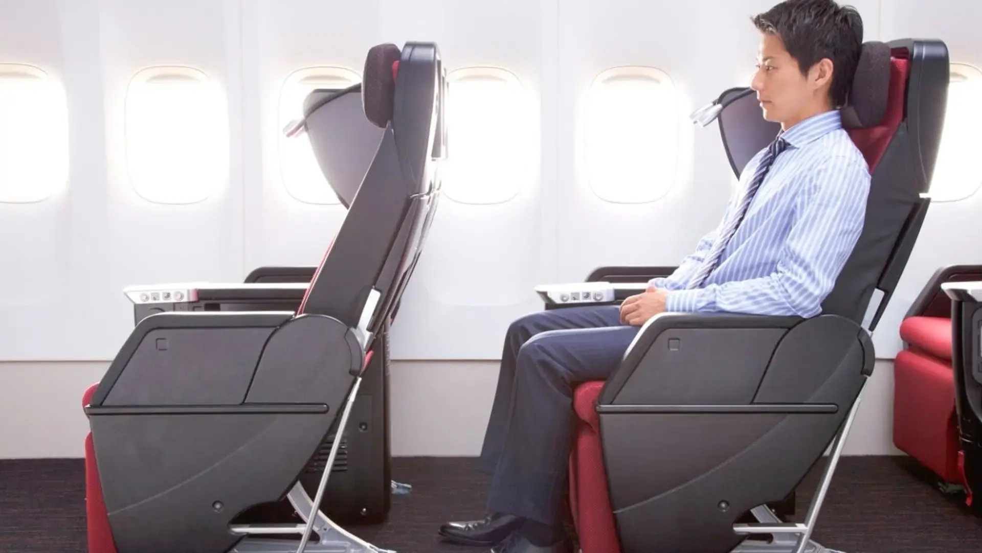 a man sitting in Japan Airlines Premium Economy